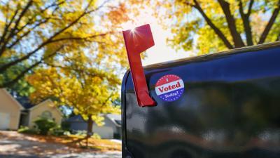 A mailbox with its flag raised and a sticker on it saying "I Voted Today!"