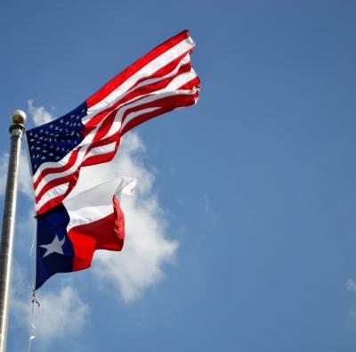 The flags of texas and the United States fly together