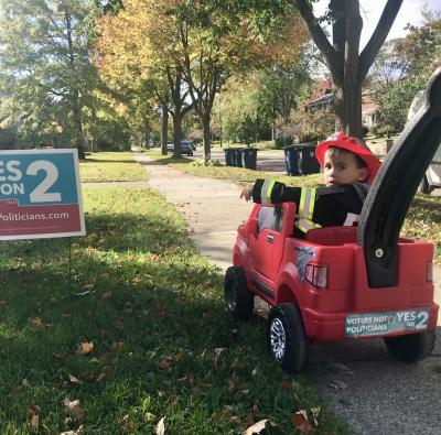 This photo is of Nancy's then two-year old son, Kai, who pedaled door-to-door canvassing to spread the word about Prop 2. Photo courtesy of Voters Not Politicians. 