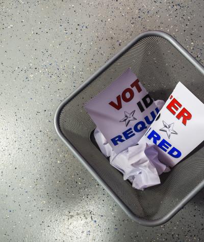 "Voter ID required" sign in a trash can