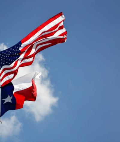 The flags of texas and the United States fly together