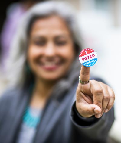 woman holding I Voted sticker