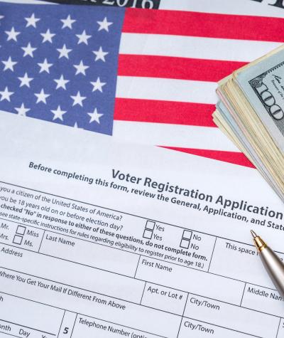 voter registration application with money on an American flag