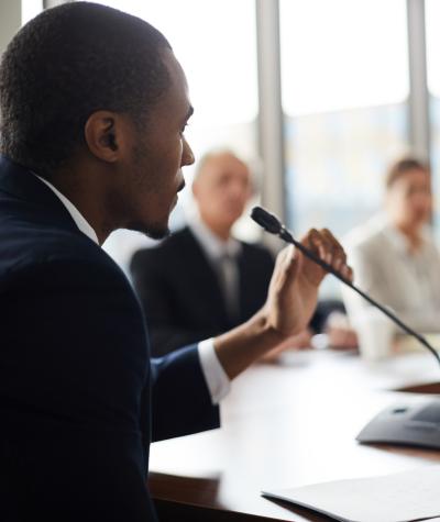 Man speaking into microphone at a meeting