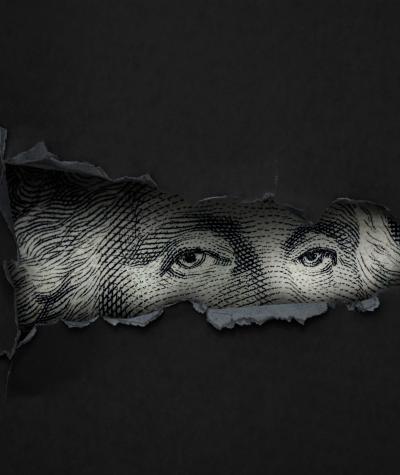 Eyes of George Washington from a one dollar bill peering through a torn black piece of paper.