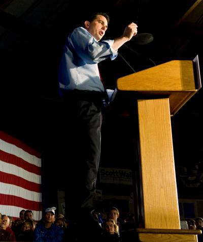 Scott Walker giving a speech at a podium with an American flag in the background.