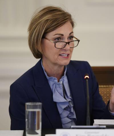 Kim Reynolds wearing glasses and speaking white seated at a desk