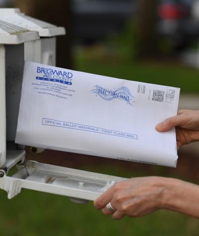 An envelop being put into a mailbox