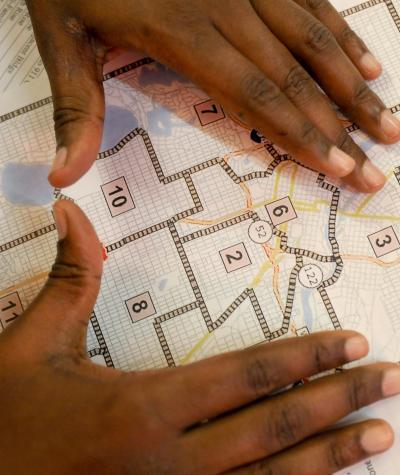 A Black person lays their hands on a congressional district map
