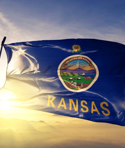 The state flag of Kansas with a sunburst in the background
