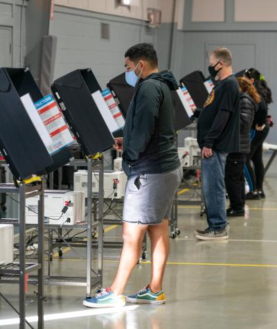 Voters cast their ballots at a long line of polling machines in a gym