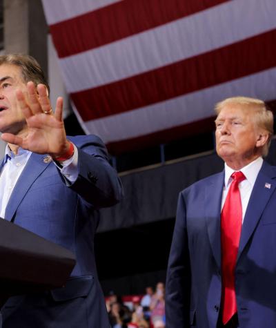 Do. Mehmet Oz speaking at a podium with Donald Trump standing directly behind him