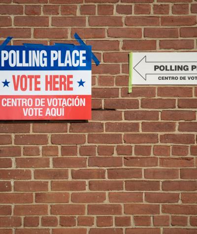 Signs on a brick wall outside a polling place
