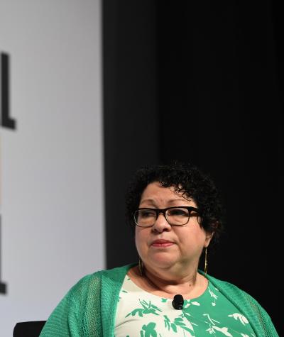 Sonia Sotomayor seated in front of a sign which says "National Book Festival"