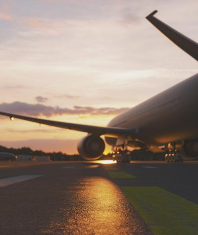 An airplane on a runway at sunset