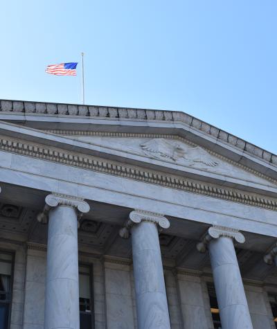 American flag flies above the Rayburn House Office Building.