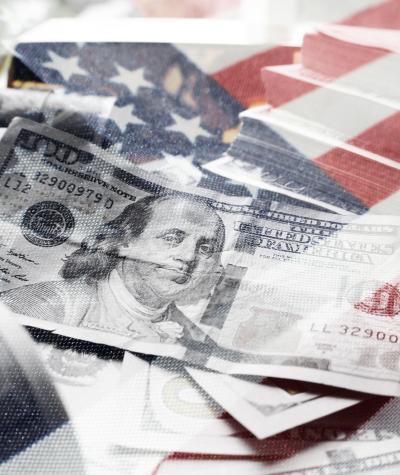 $100 bills on top of the American flag.