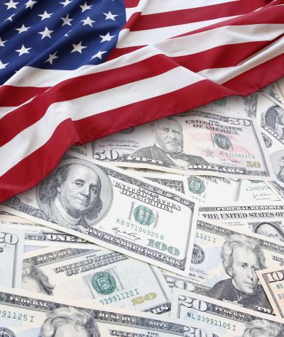 US currency partially covered by an American flag