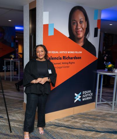 Valencia Richardson posing in front of a large poster of herself.