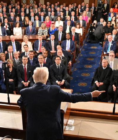 Trump gesturing while speaking to seated members of Congress and Supreme Court justices with his back to the camera