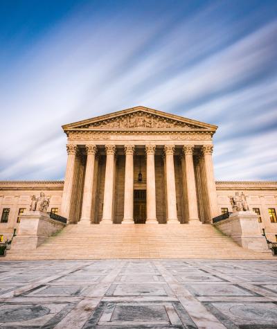 The front of the U.S. Supreme Court building with clouds behind it