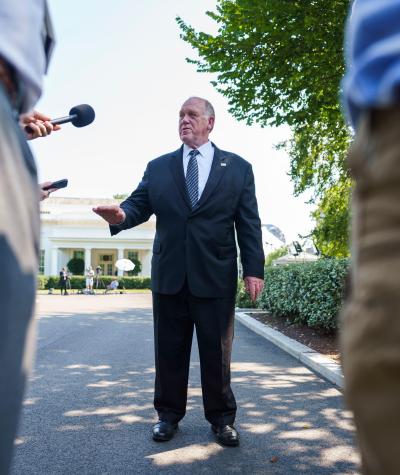 Tom Homan in front of the White House talking to press with microphones