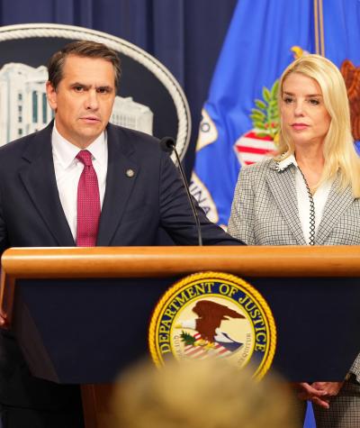 Todd Blanche speaking from behind a podium with Pam Bondi standing next to him