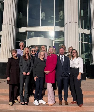 A group of people standing on the steps of a courthouse.