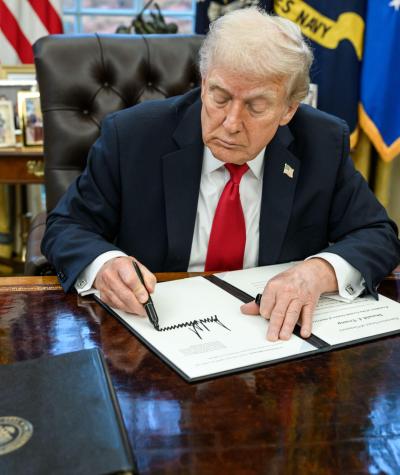 Donald Trump at his desk signing a pardon