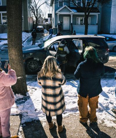 Community members react to Immigration and Customs Enforcement (ICE) agents as they detain a man in Minneapolis, Minnesota. 