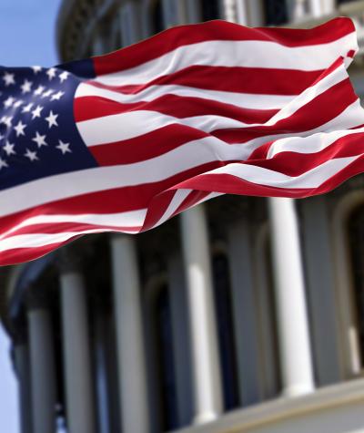 An American flag flying in front of the U.S. Capitol Building