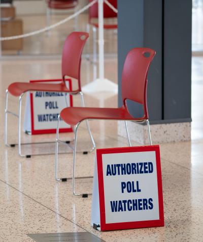 Two empty chairs and two signs that say "Authorized Poll Watchers".