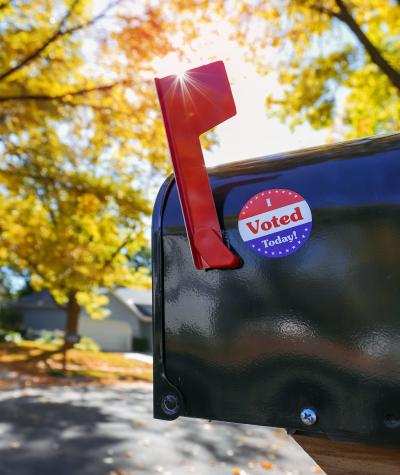 A mailbox with its flag raised and a sticker on it saying "I Voted Today!"
