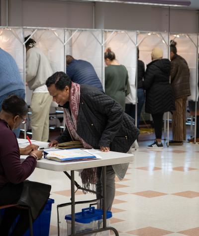 Voters at a polling place checking in and casting ballots.