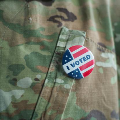 Close up of a person in fatigues with an "I Voted" pin