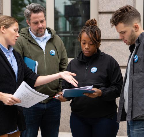 A group of people looking at a clipboard