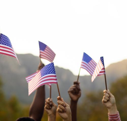 Hands waving small American flags