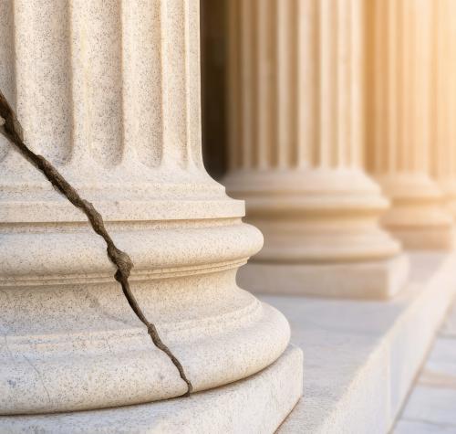 Cracked broken justice stone pillar in vintage courthouse.