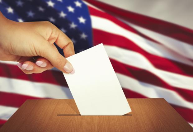 Voter's hand placing ballot into box