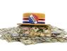 A straw hat with a red white and blue ribbon and a "Vote" button on it sitting on top of a pile of money.