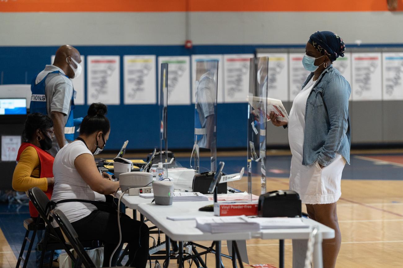 A voter wearing a facemask checks in at a voting site in DC
